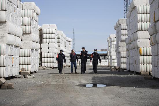 民警与货场安全员一道对棉花存放地进行安全巡检。